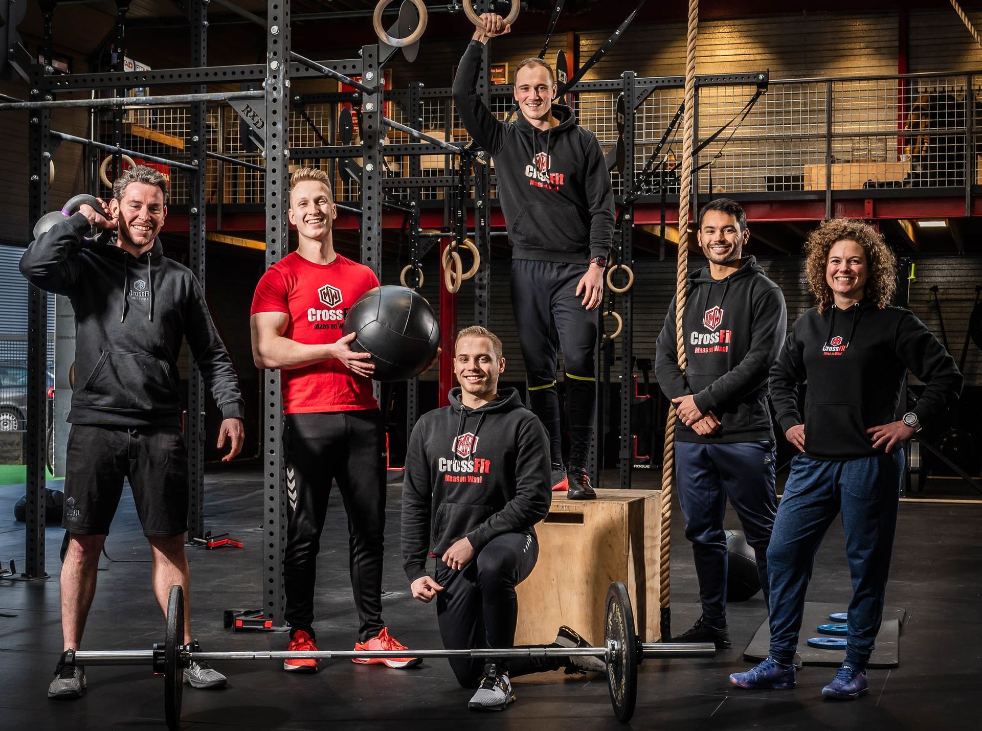 Een groep mensen poseert voor een foto in een sportschool.