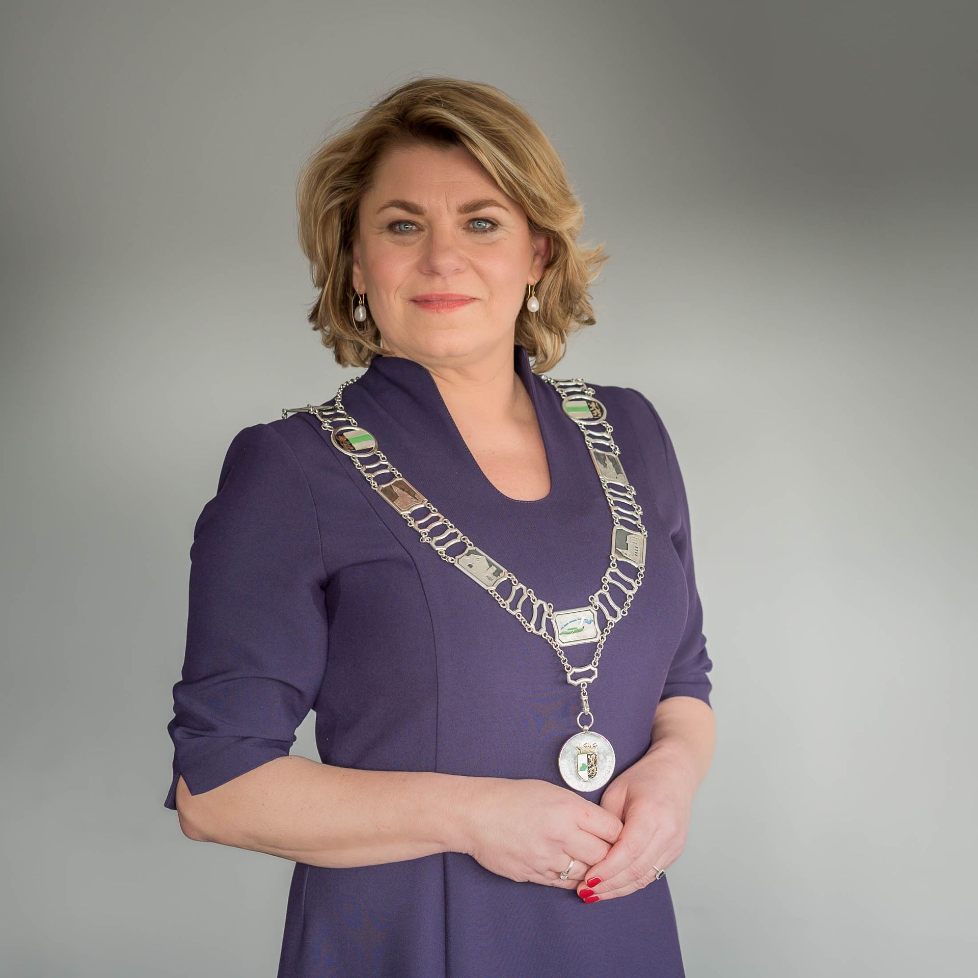 Een vrouw in een paarse jurk draagt een ketting om haar nek.