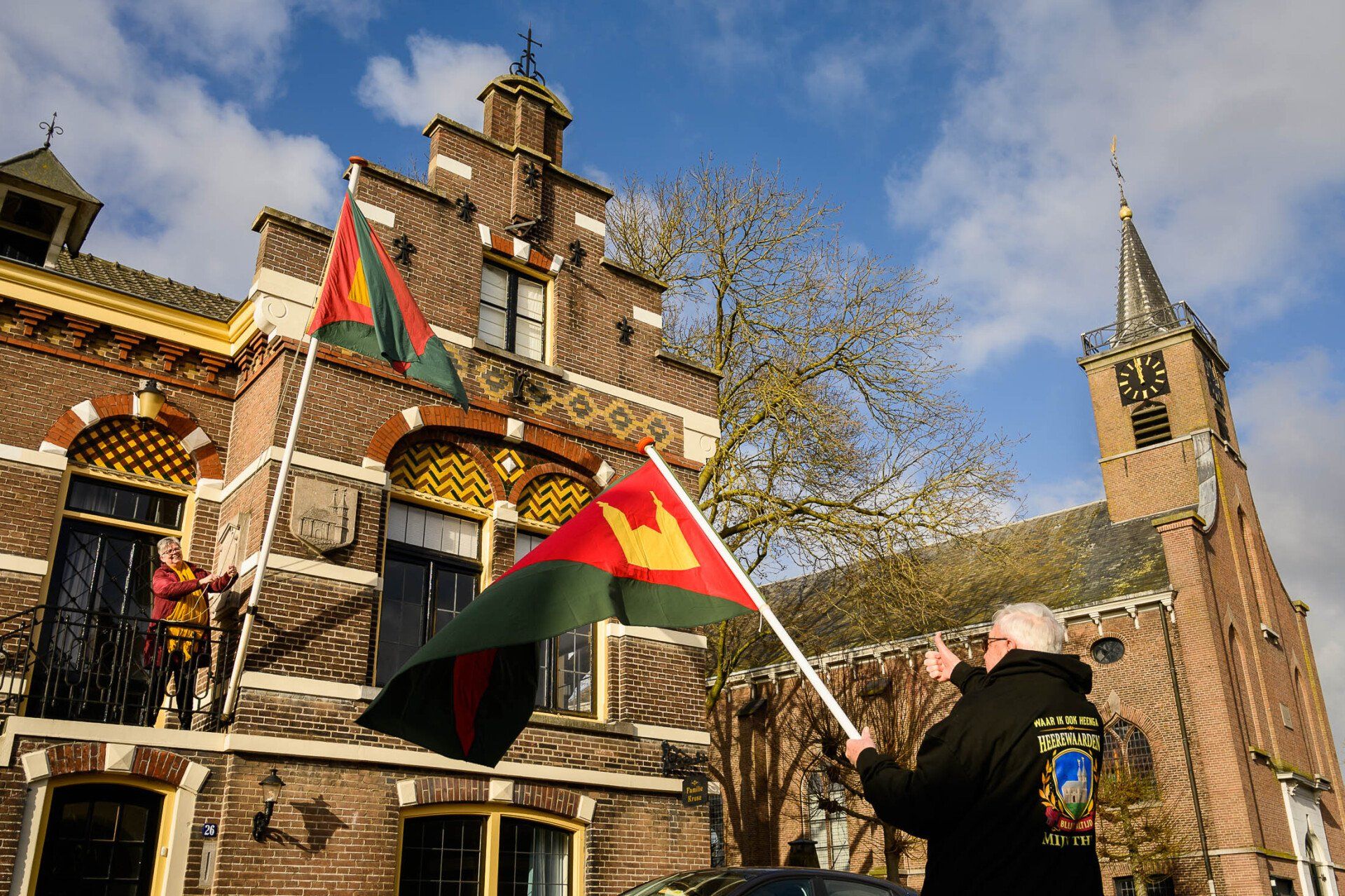 Een man houdt een vlag vast voor een gebouw