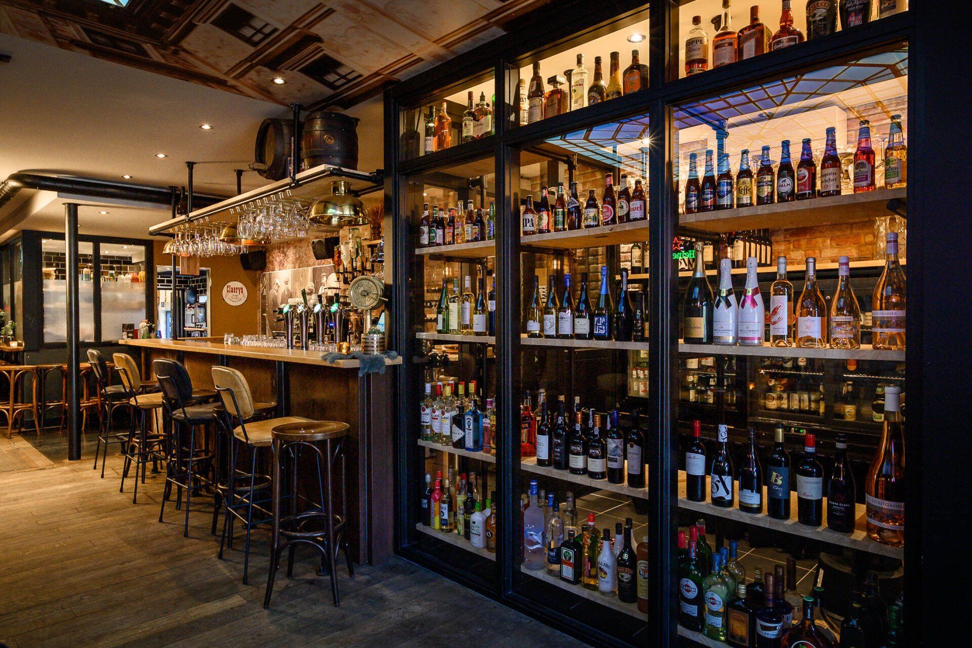 Een bar met veel flessen alcohol op de planken