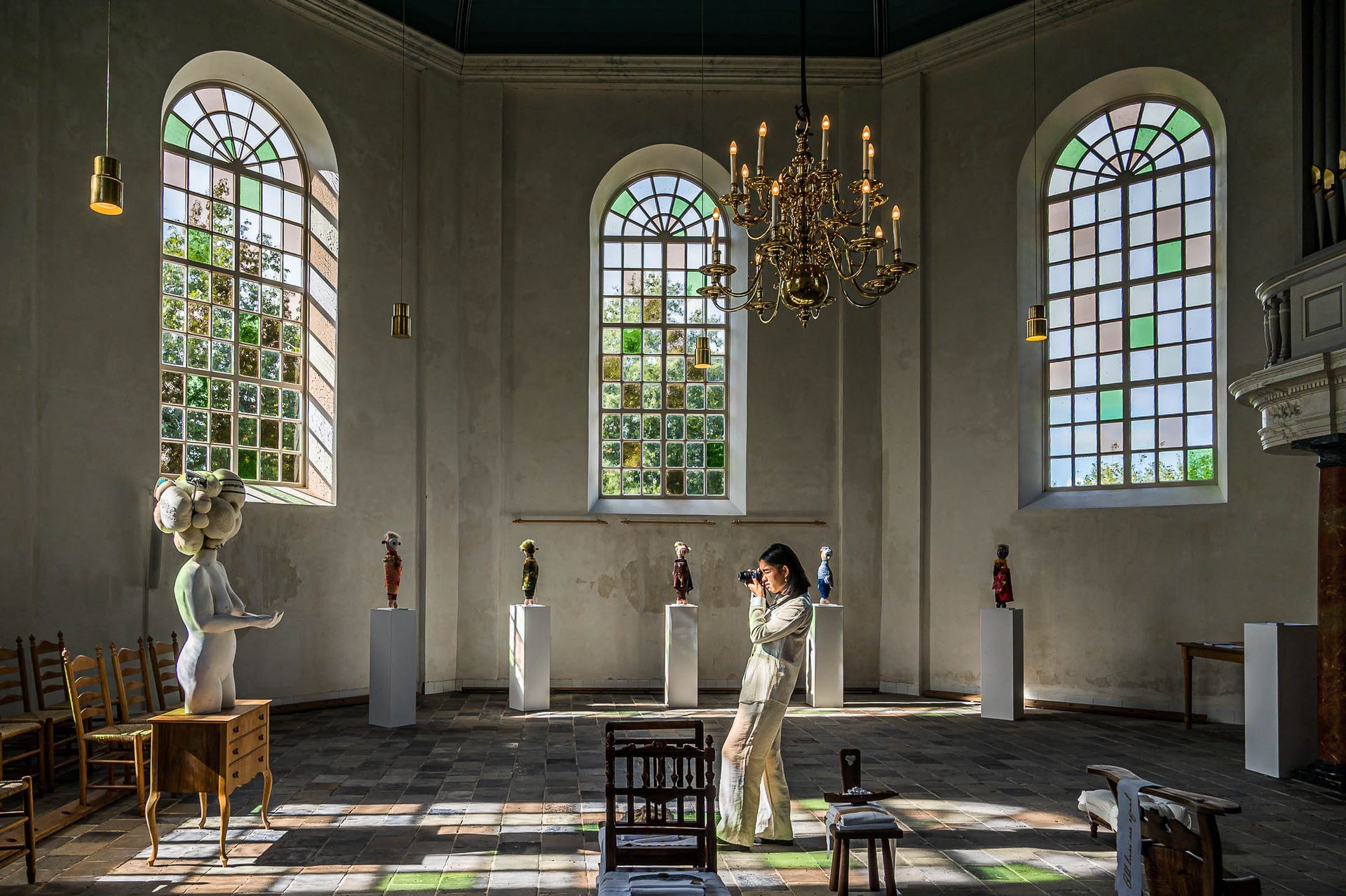 Een vrouw maakt een foto van een standbeeld in een kerk.