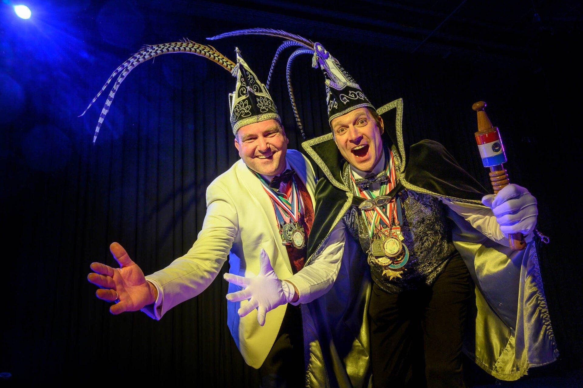 Twee mannen in kostuums staan naast elkaar op een podium.