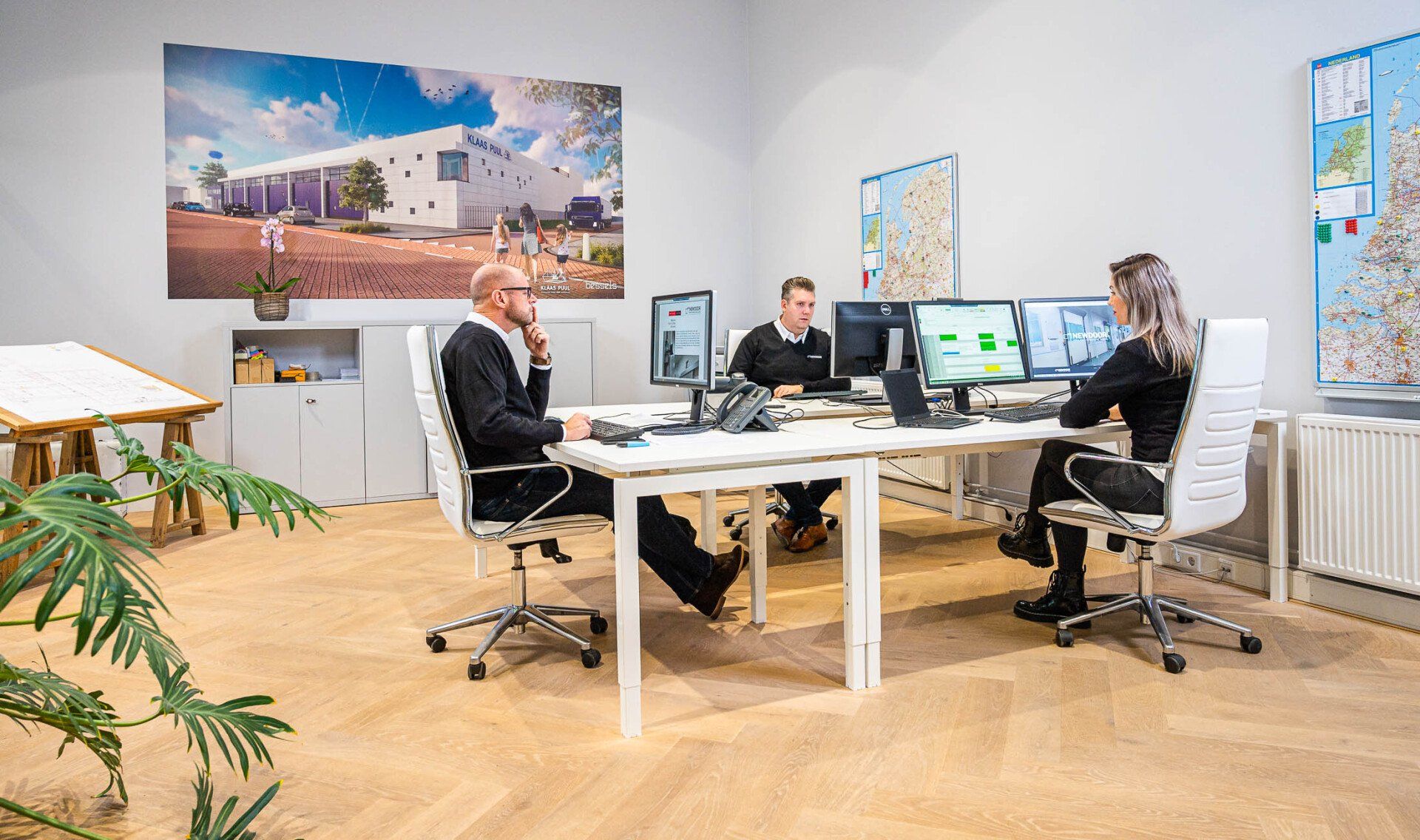 Een groep mensen zit aan een bureau op kantoor.