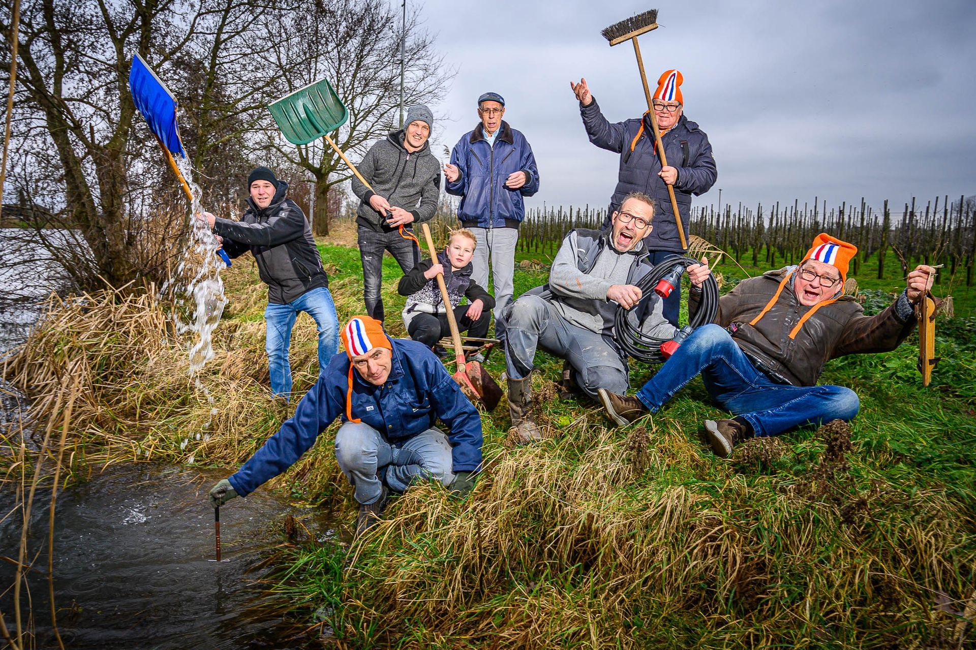 Een groep mensen poseert voor een foto in een veld.