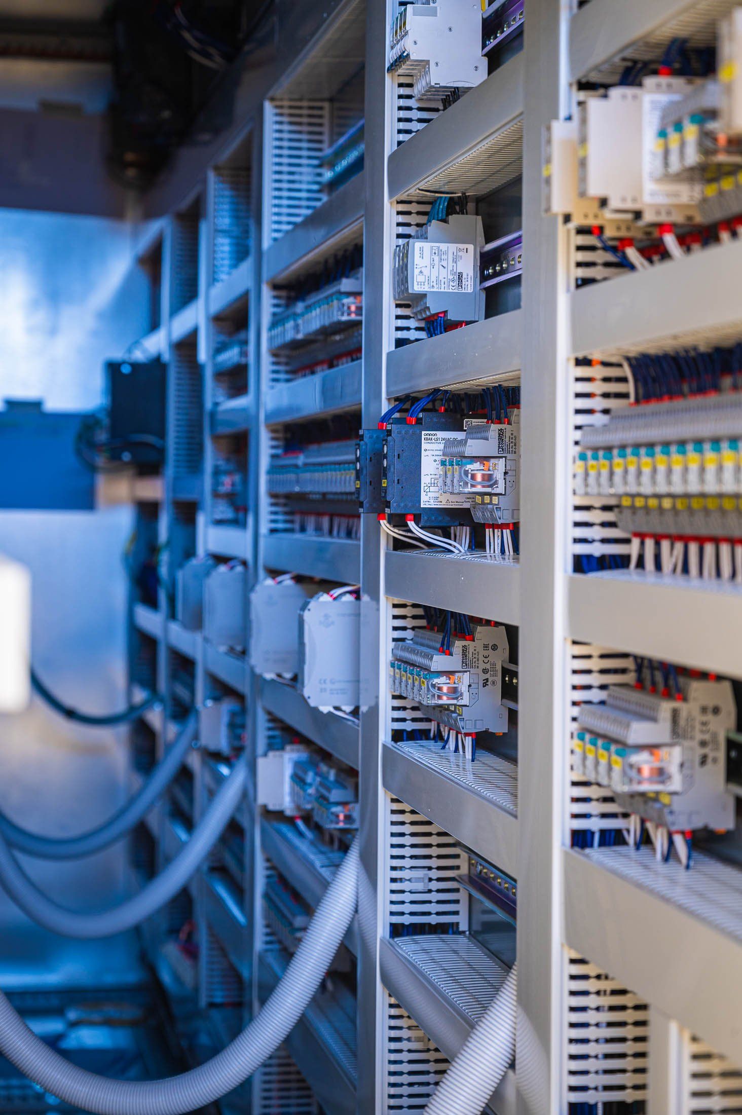 Een rij planken gevuld met elektrische apparatuur in een fabriek.