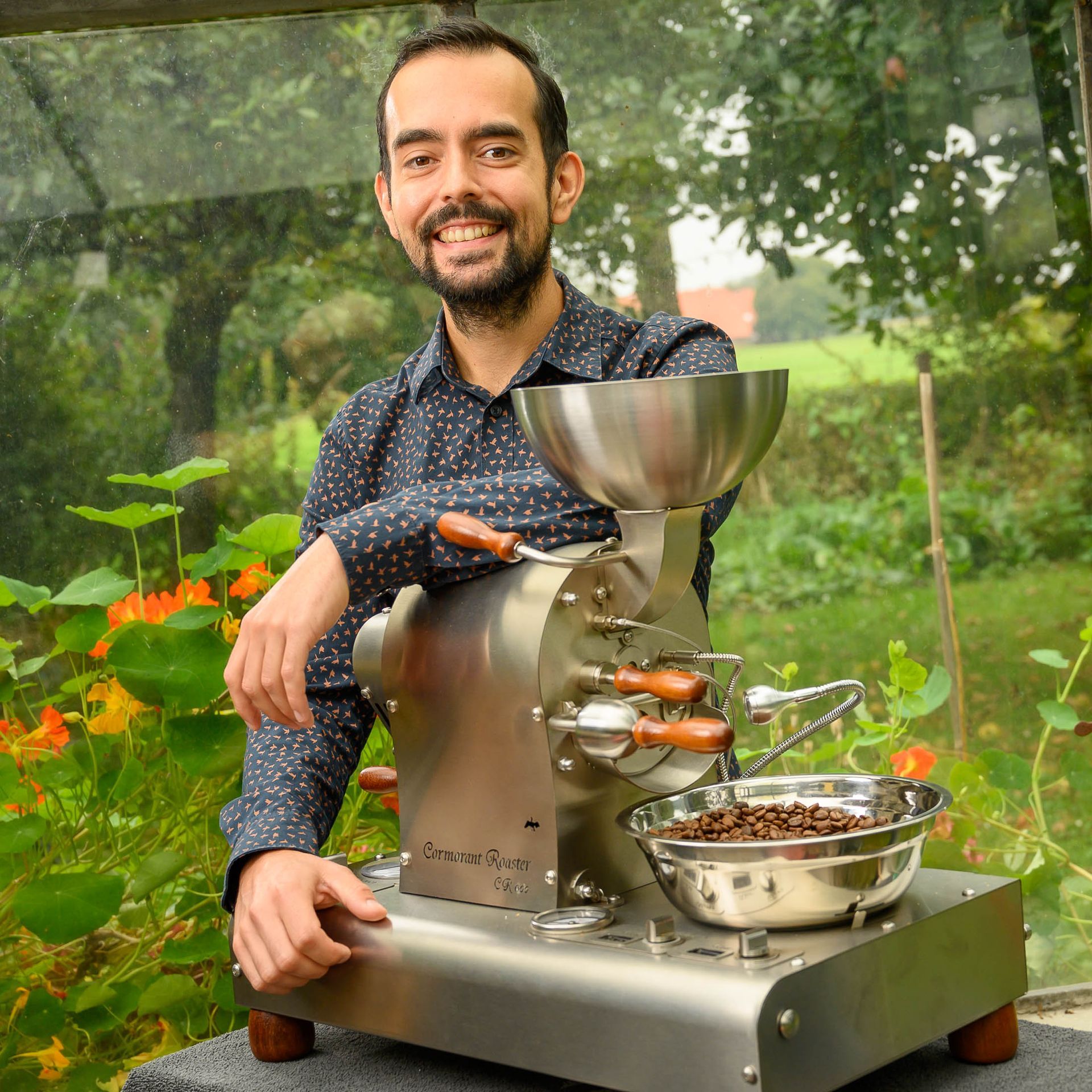 Een man in een blauw shirt zit op een koffiemolen