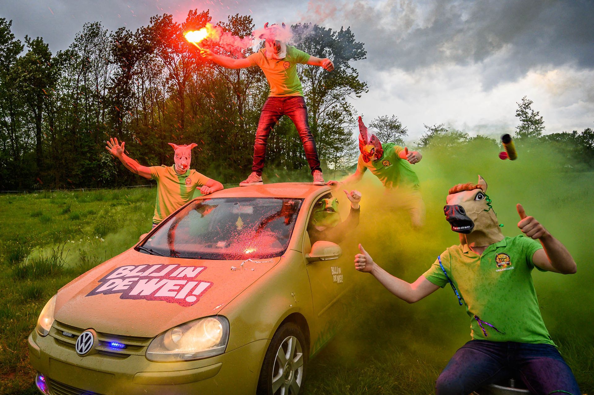 Een groep mensen die bovenop een auto staat met de tekst: alles in een wij!