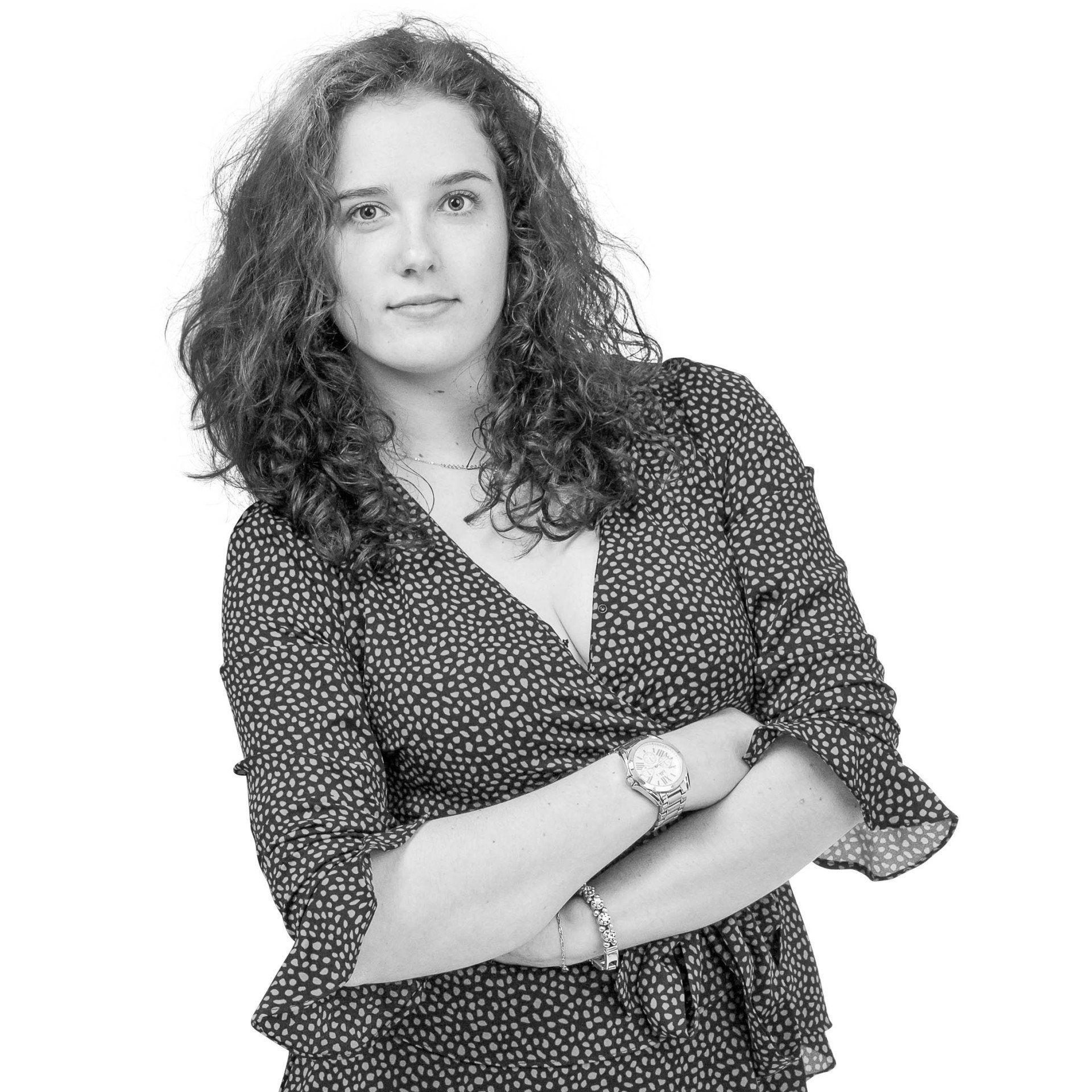 Een zwart-witfoto van een vrouw met haar armen over elkaar