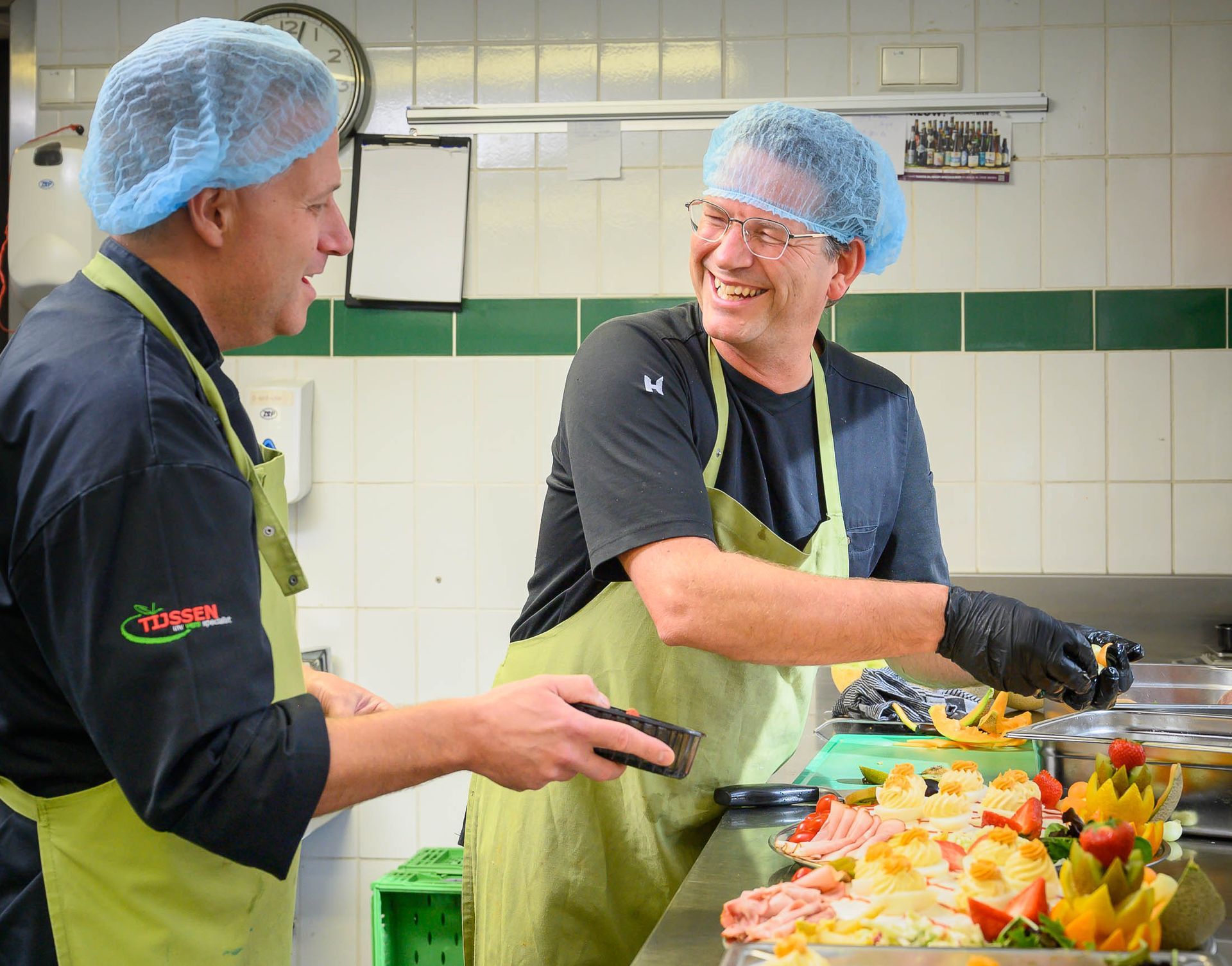 Twee mannen staan in een keuken en bereiden eten.