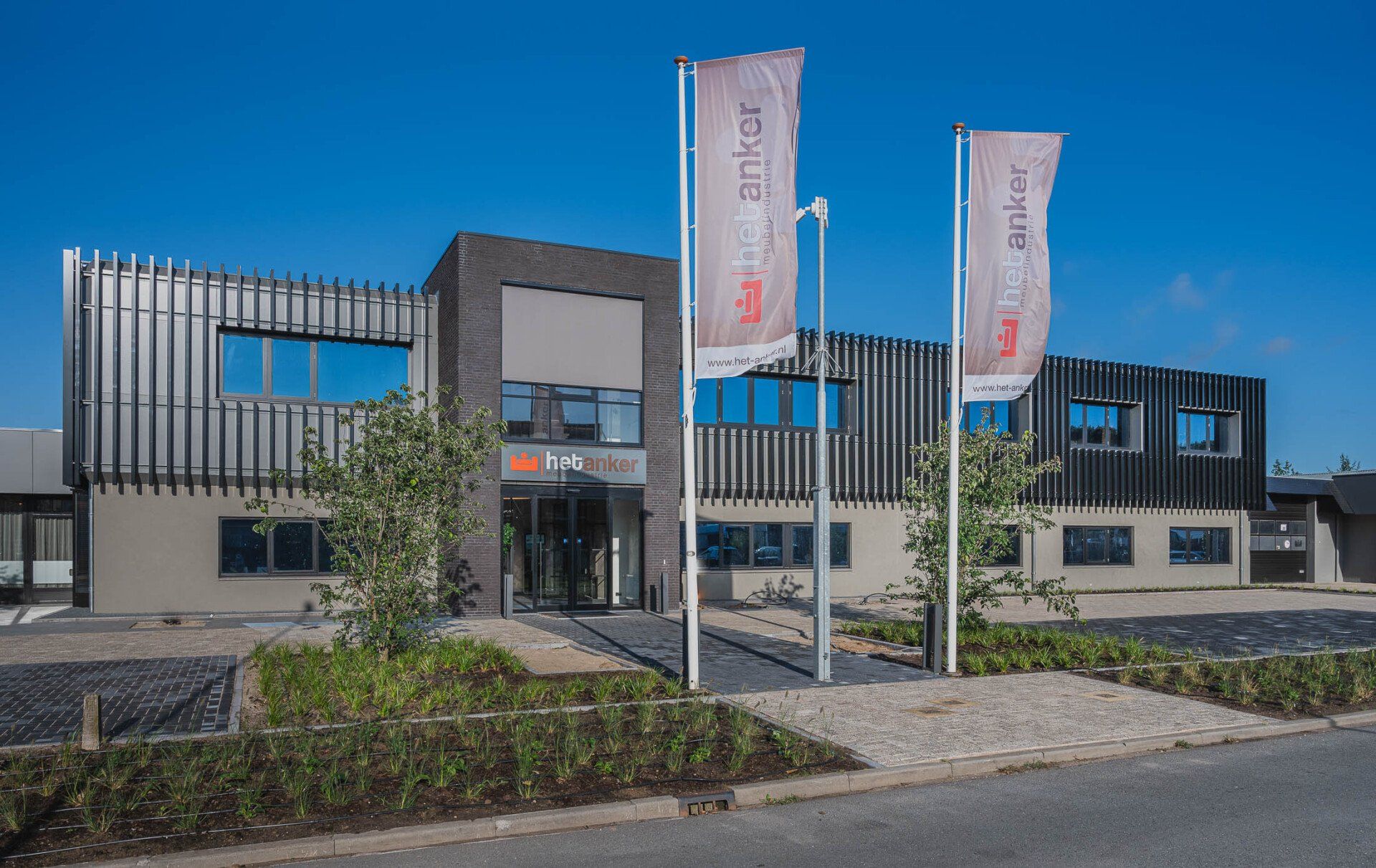 Een groot gebouw met twee vlaggen ervoor.