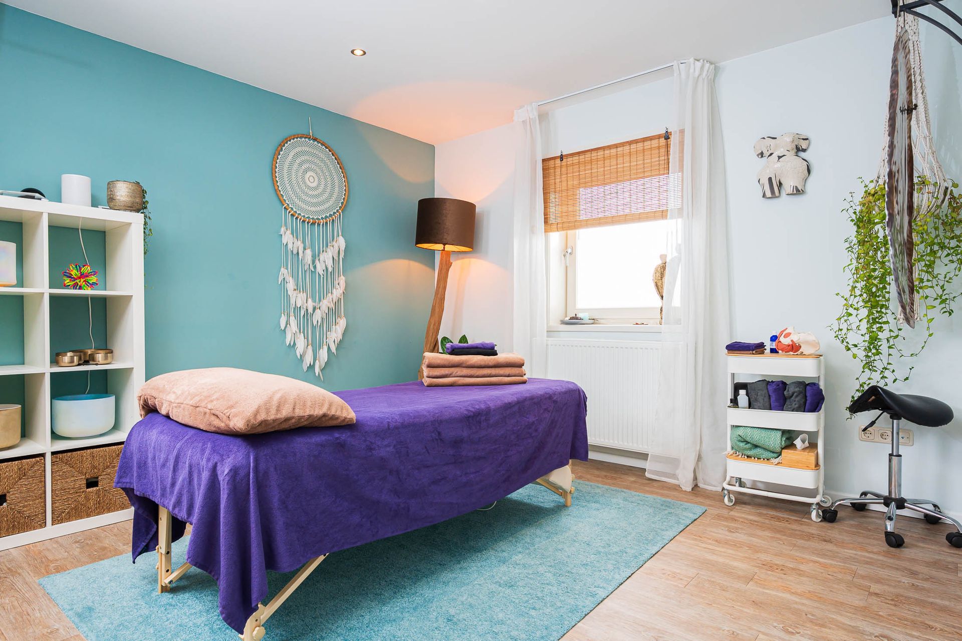 Er staat een paars bed in het midden van de kamer.