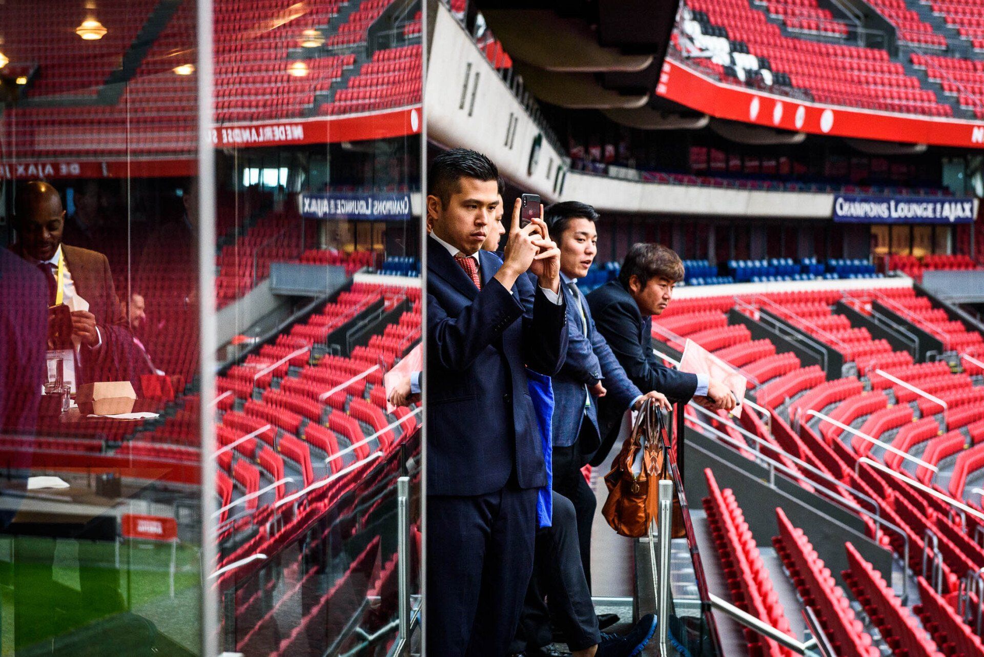 Een groep mensen staat in een stadion foto's te maken.