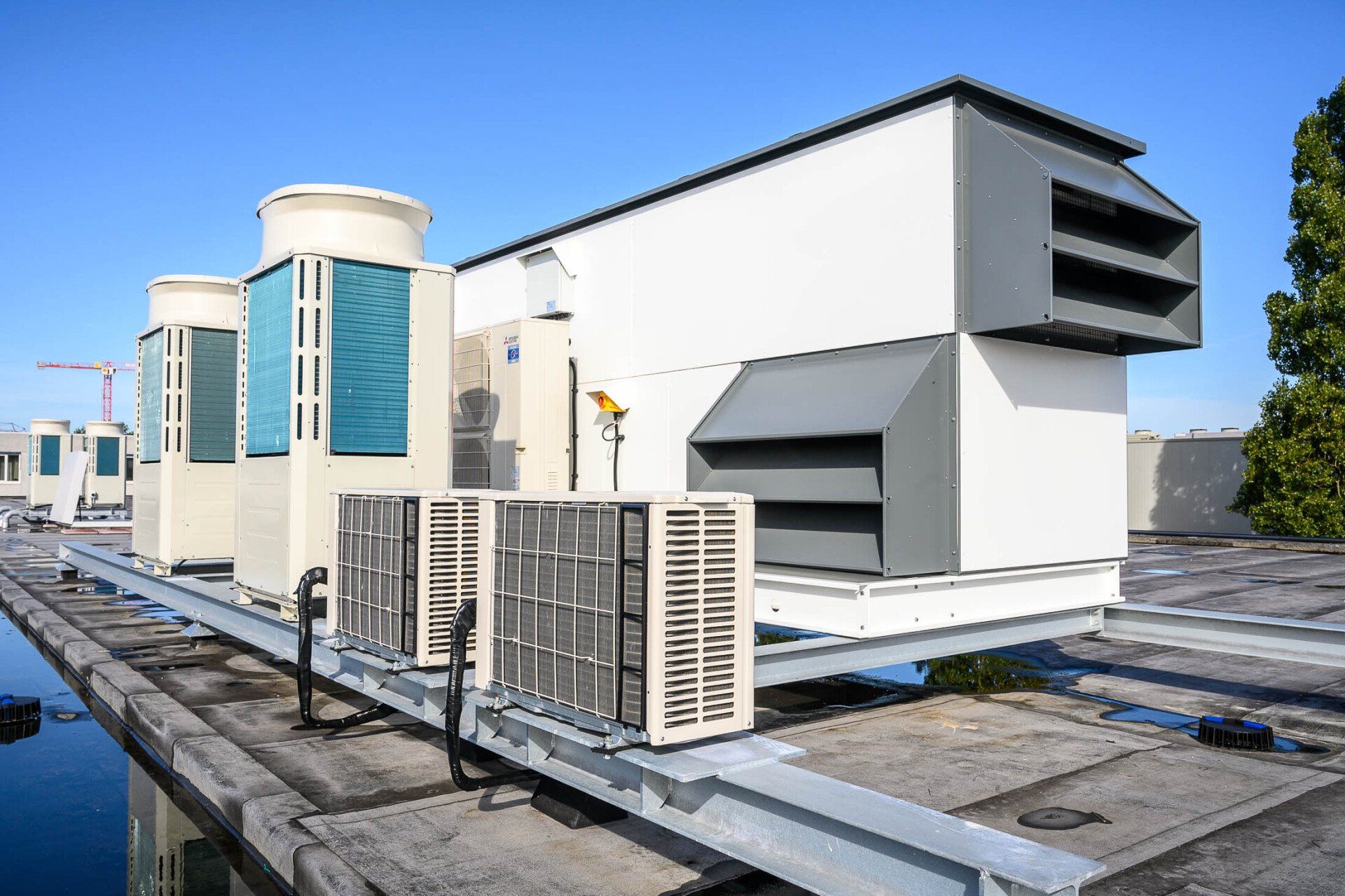 Er staan veel airconditioners op het dak van een gebouw.