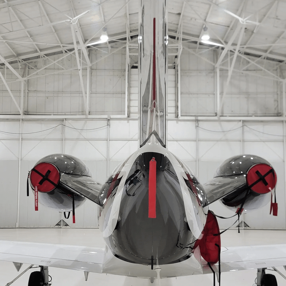 A plane in a hangar has a red x on the tail