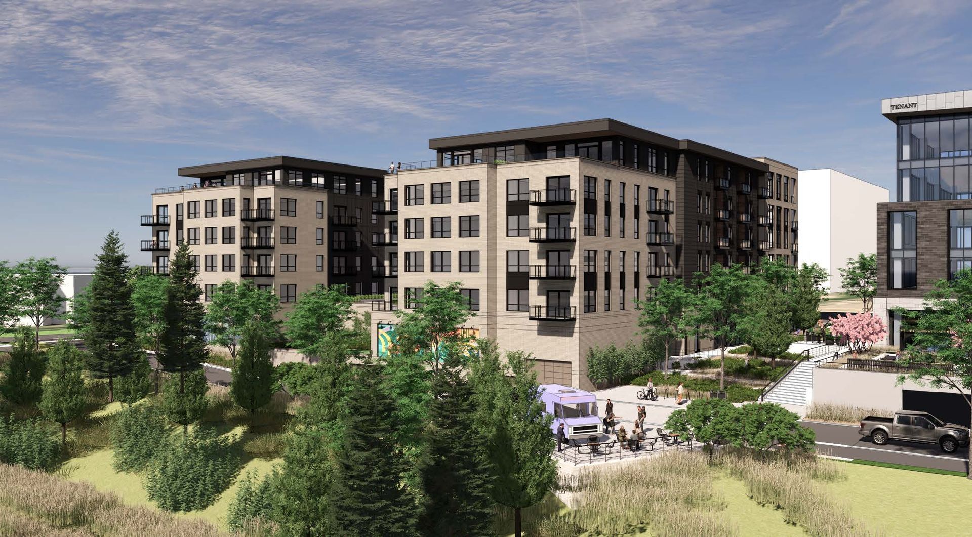 Modern apartment buildings amid trees and landscaped grounds on a sunny day