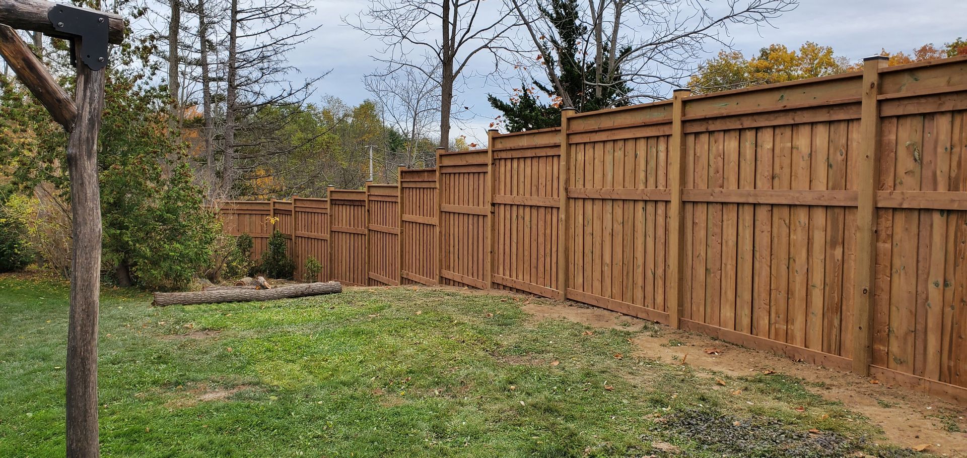 a wooden fence surrounds a lush green yard
