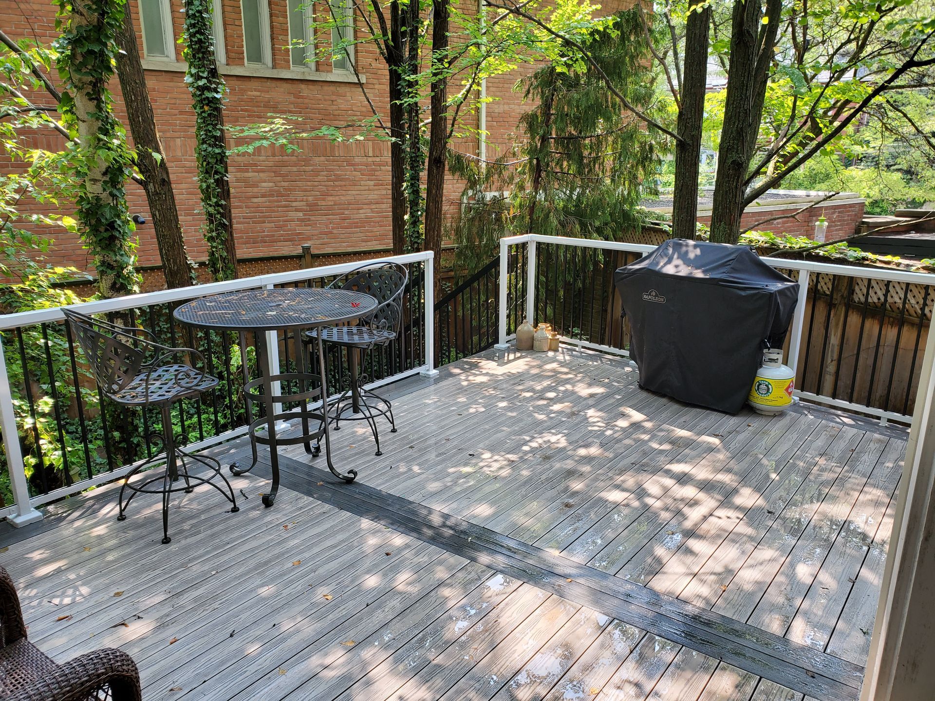 a wooden deck with a table and chairs and a grill .
