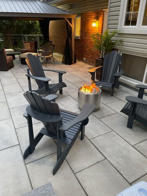 a wooden deck with chairs and a table with flowers on it