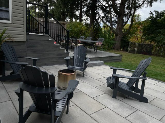 a patio with chairs and a table in the backyard