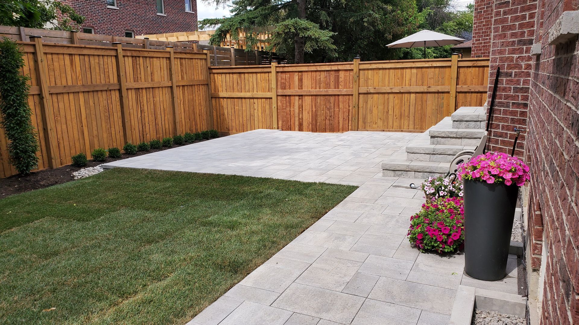a backyard with a wooden fence and a patio .