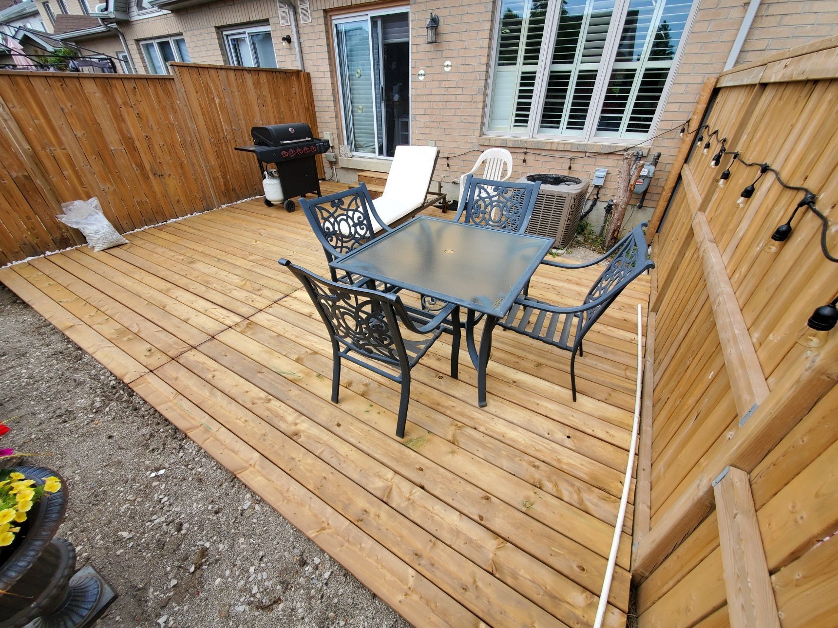a wooden deck with a table and chairs on it .