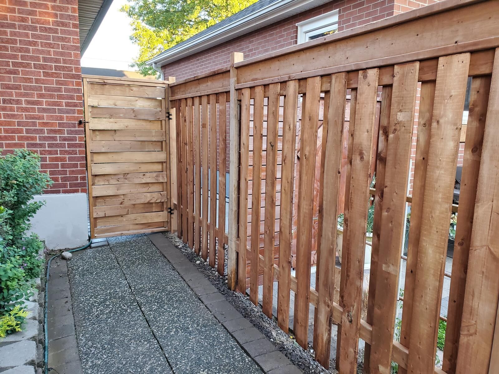 a wooden fence is sitting next to a brick building .
