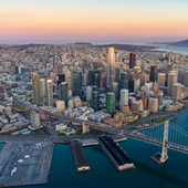 Aerial view of San Francisco skyline at sunset with the Bay Bridge and waterfront piers