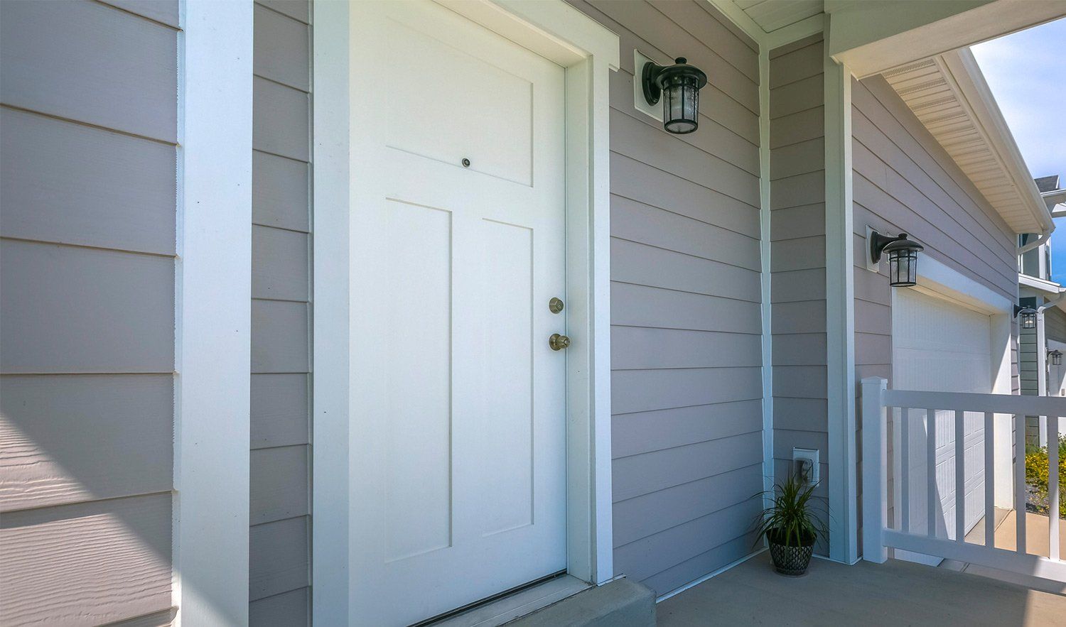 House Siding — Gig Harbor, WA — Harbor Quality Painting, LLC Close-up of newly painted beige house siding and front door on a covered porch.