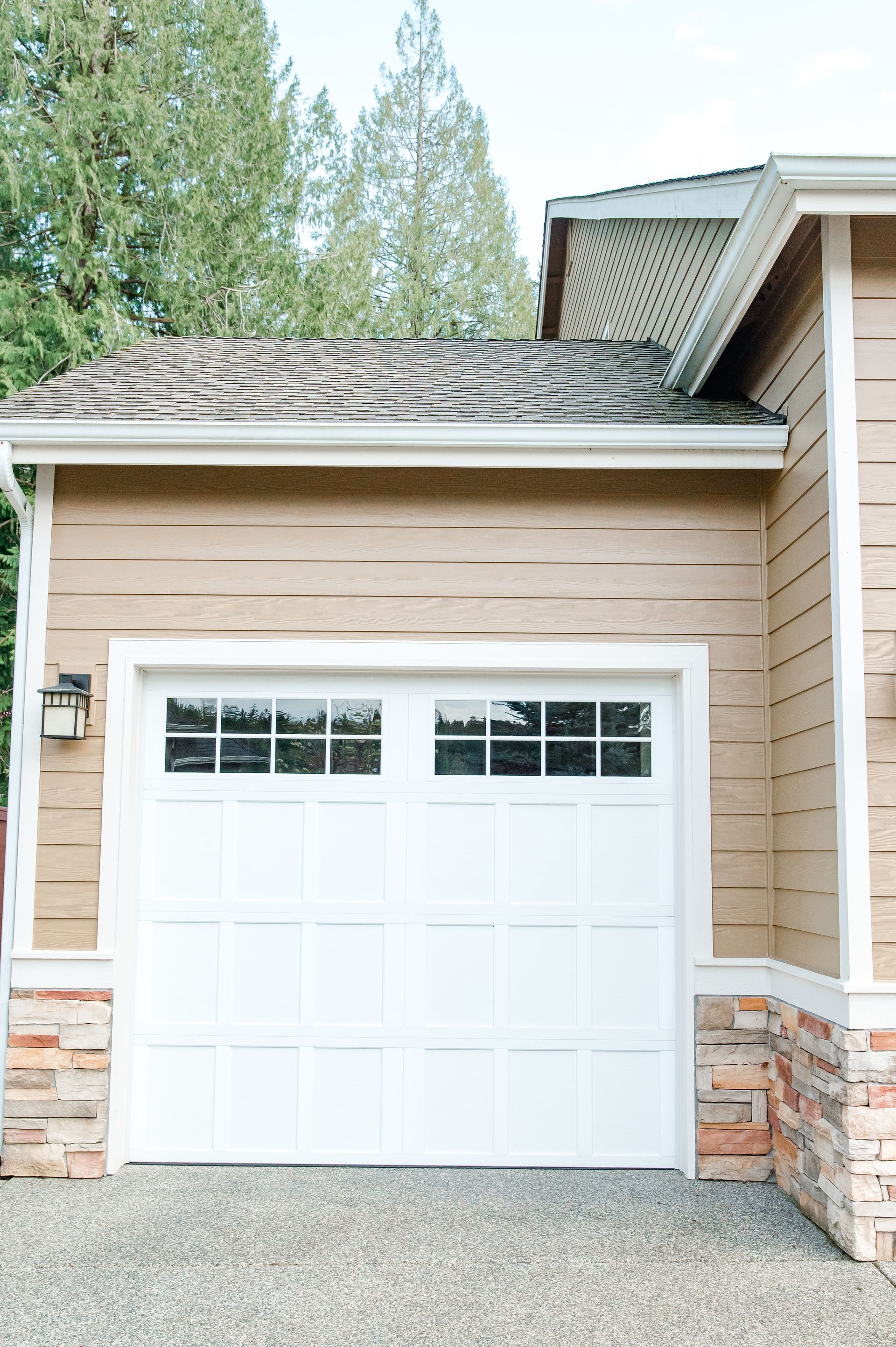 A white garage door is on the side of a house.