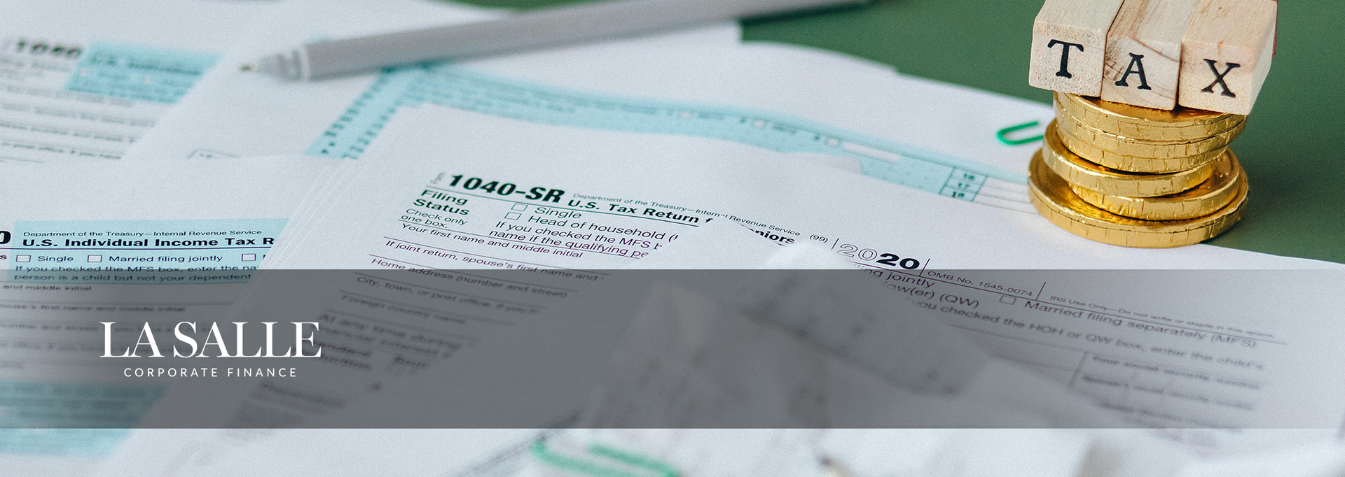 Tax forms with coins spelling “TAX” and a “Lassie” financial watermark banner