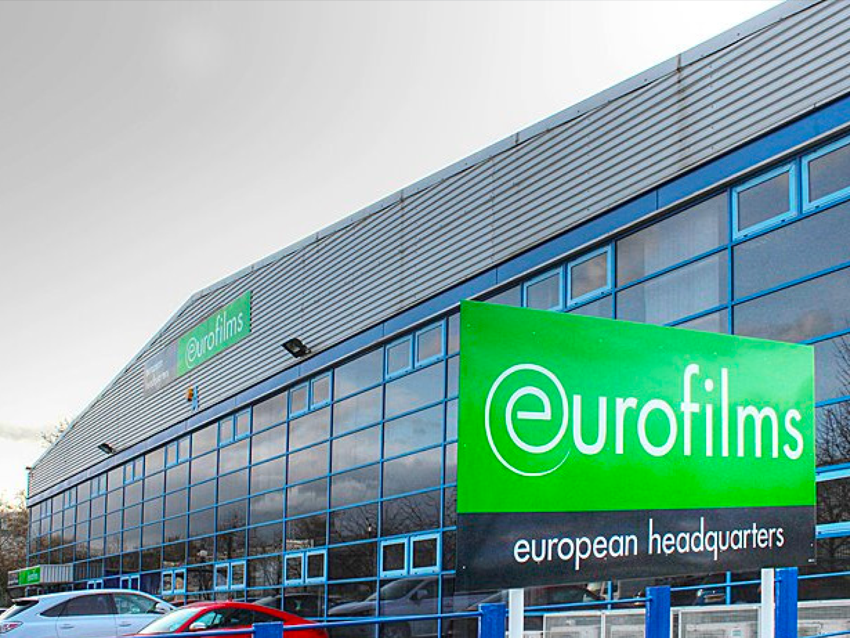Eurofilms European headquarters building with large green sign on a glass facade