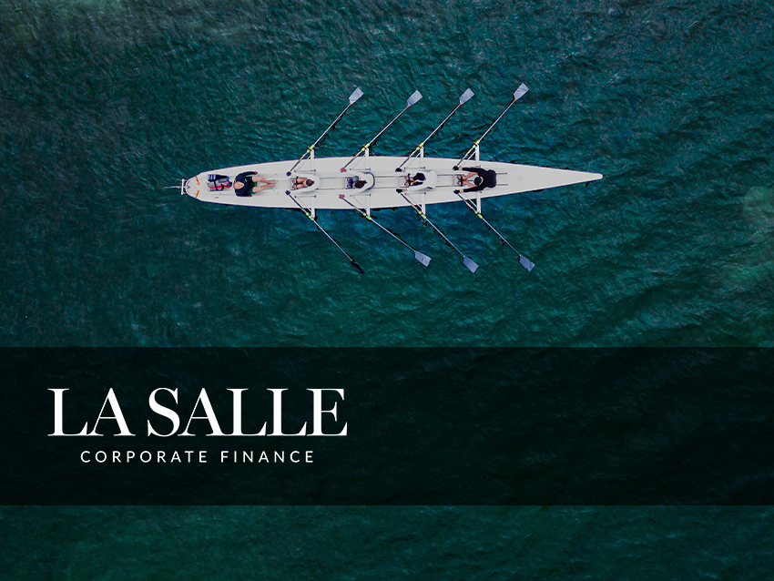 Overhead view of a rowing team in a white shell on teal water, with 
