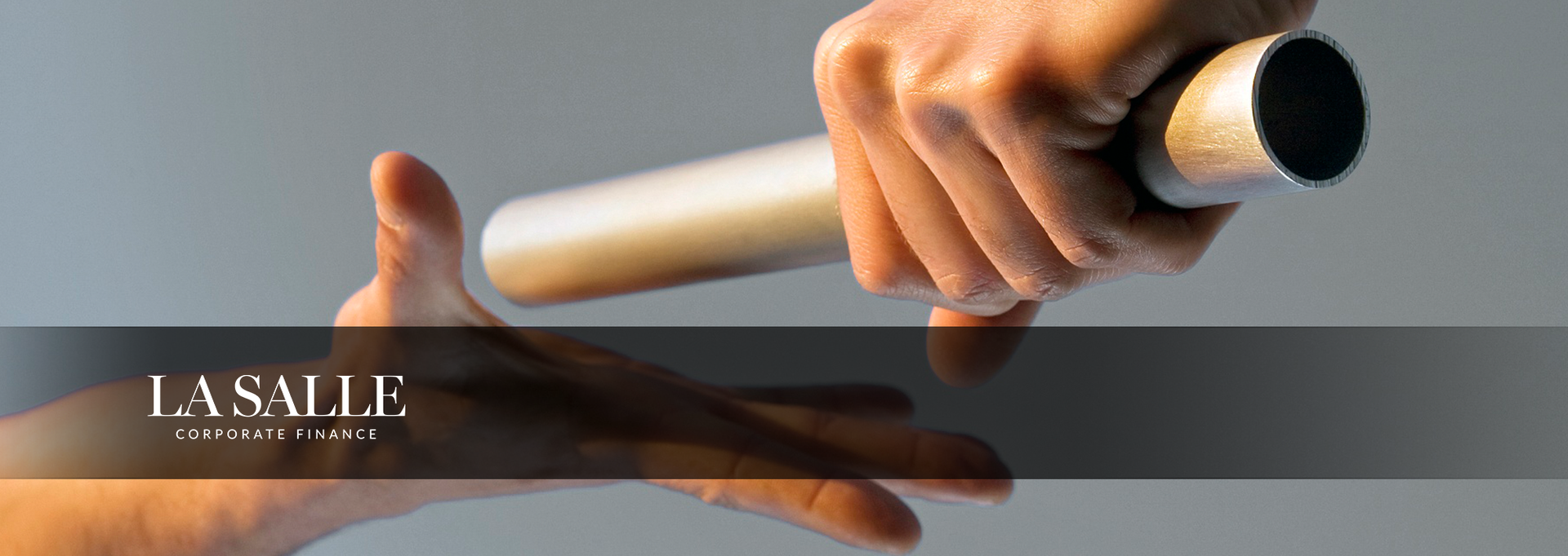Hand holding a white rolling pin over a glossy black surface with the word “LA SAUL” visible