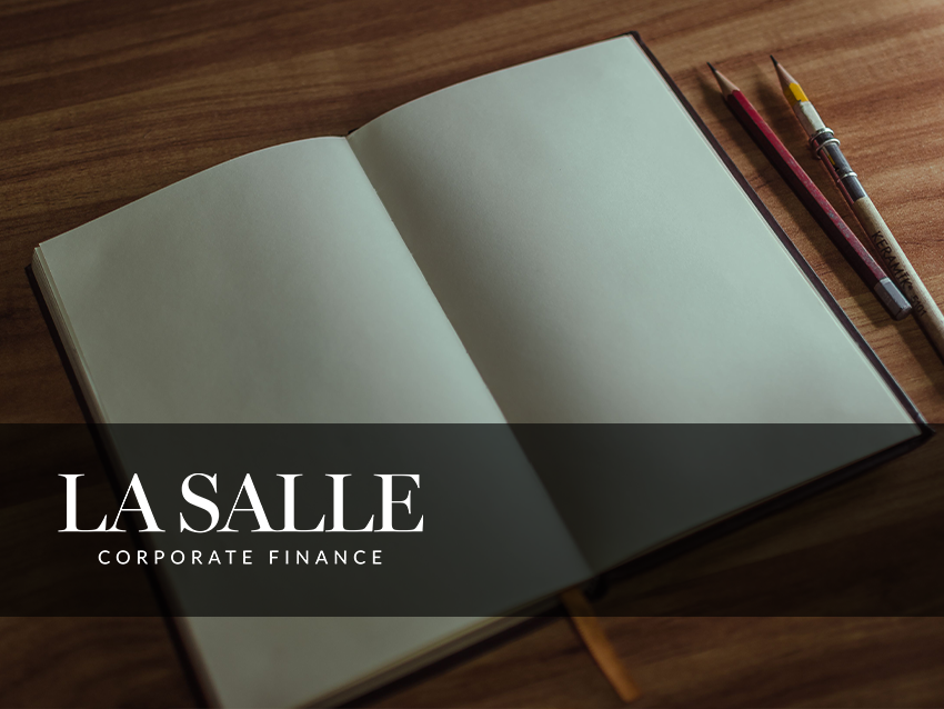 Notebook on wooden desk with pencils, overlaid with “LA SALLE Corporate Finance” logo