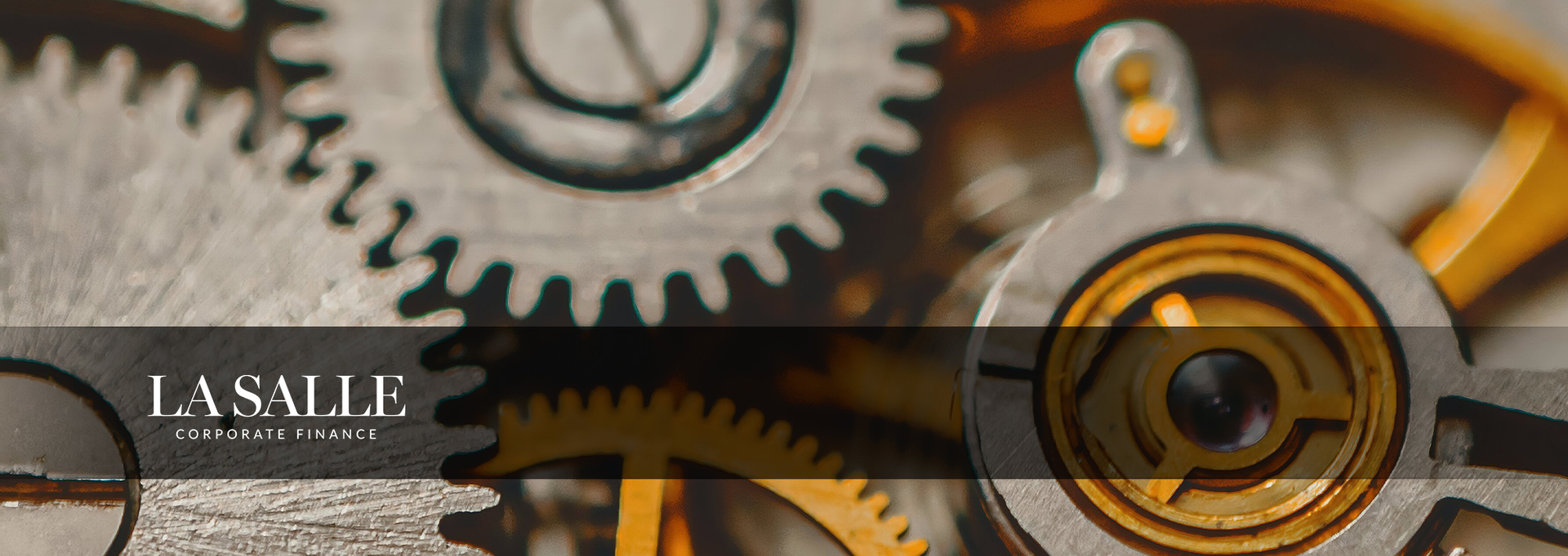 Close-up of interlocking metal gears and clockwork with a black-and-gold design, beside a small logo panel.