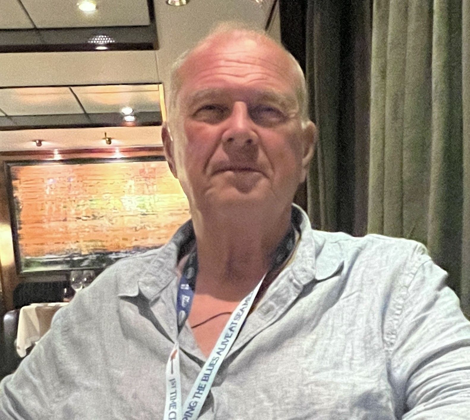 A man with a lanyard around his neck that says ' oscar ' on it