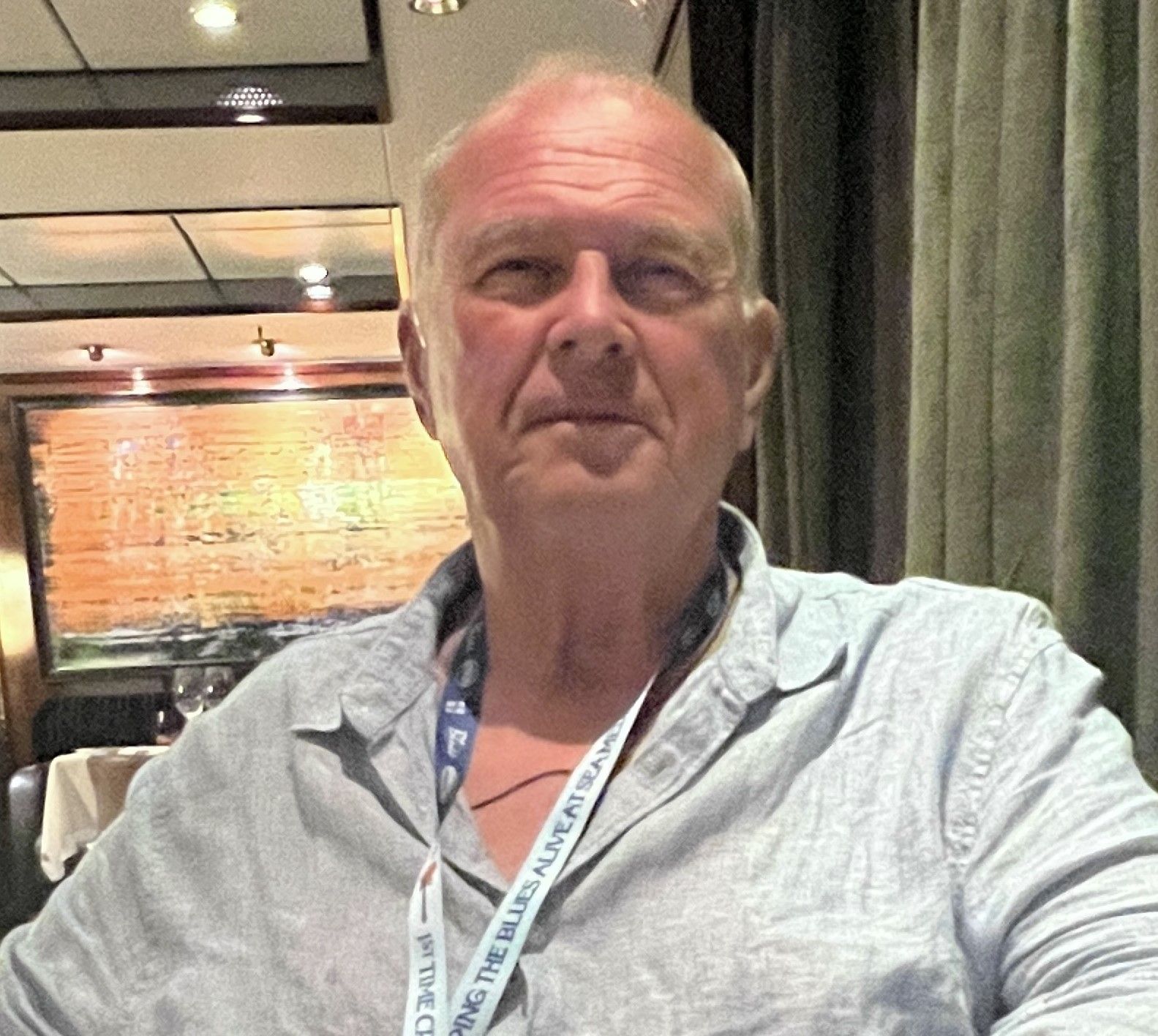 A man with a lanyard around his neck that says ' oscar ' on it