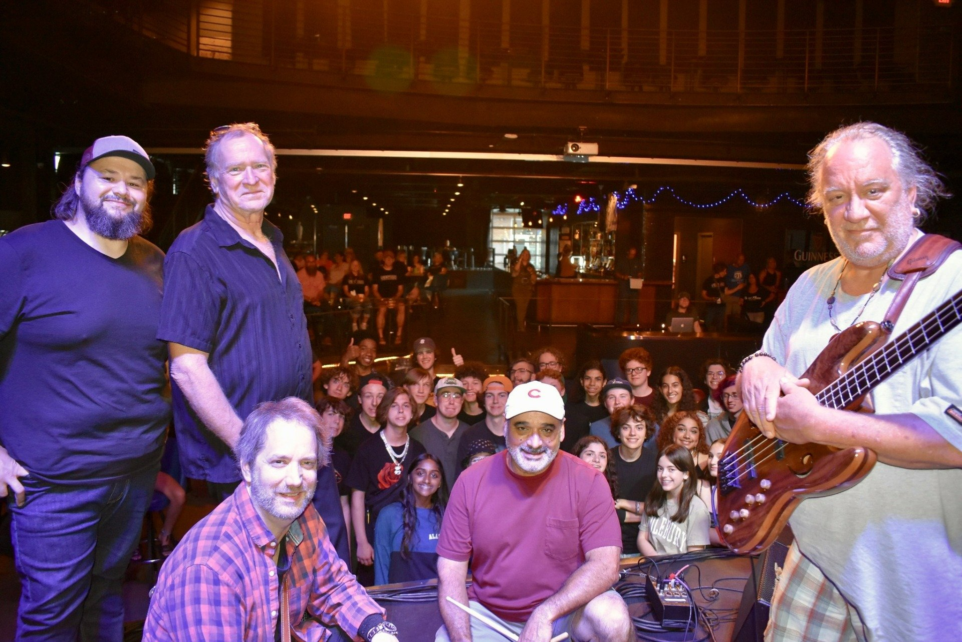 A group of men are posing for a picture on a stage in front of a crowd.