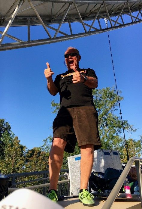 A man in a black shirt is giving a thumbs up