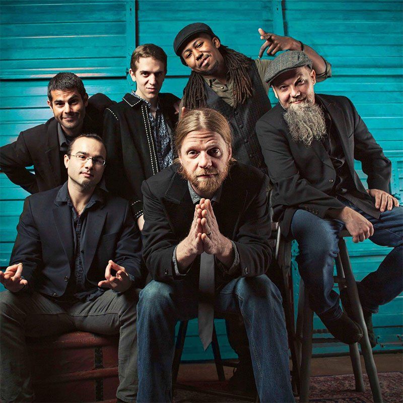 A group of men are posing for a picture in front of a blue wall