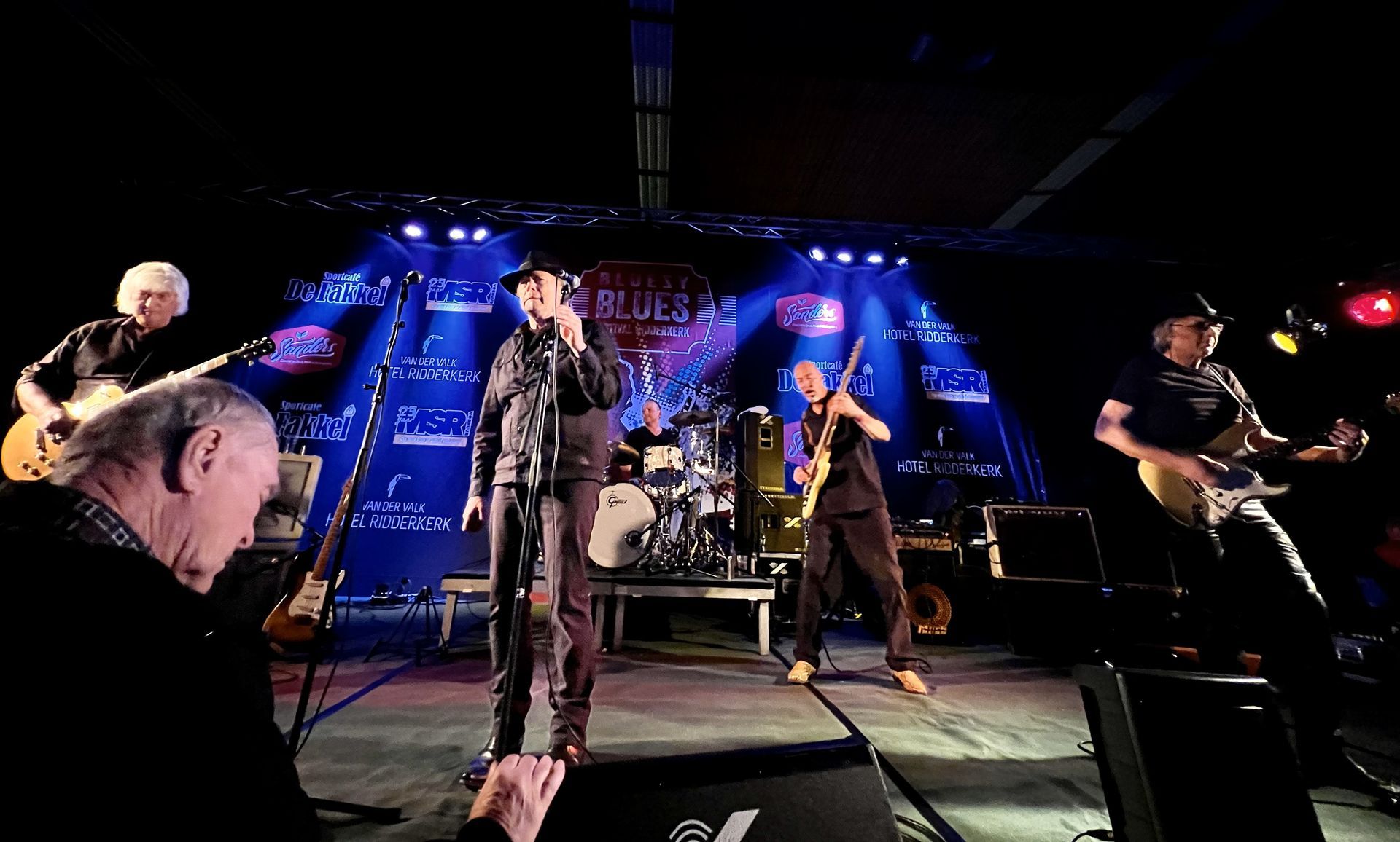 A group of men are playing guitars and singing on a stage.