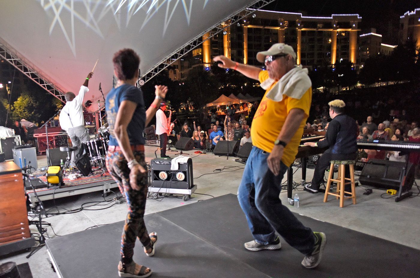 A man and a woman are dancing on a stage in front of a crowd