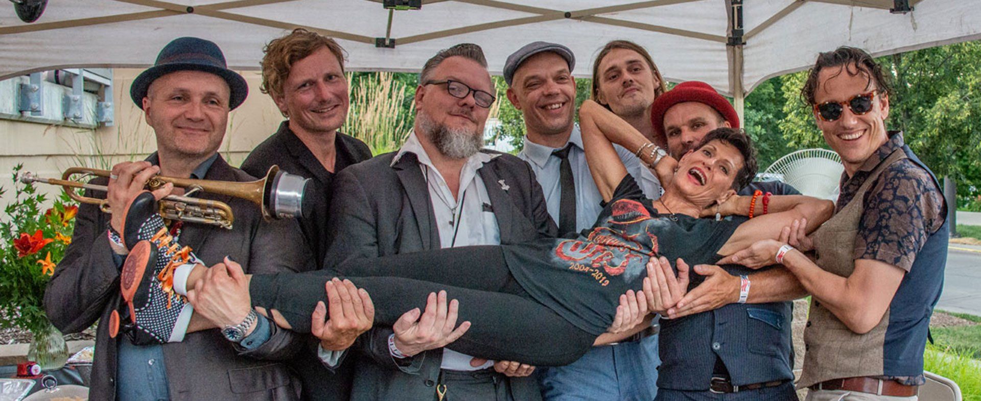 A group of men are holding a woman in their arms.