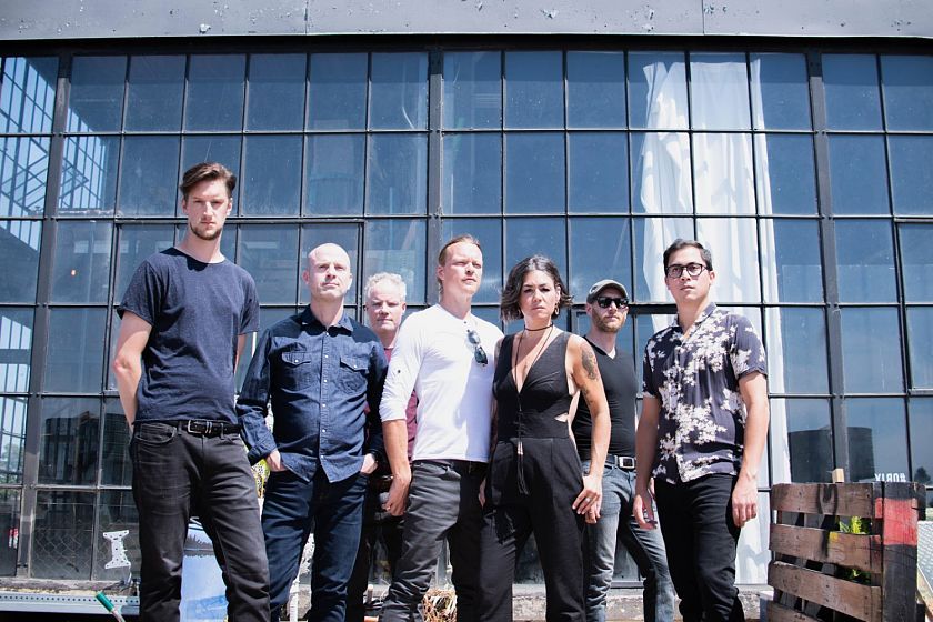 A group of people are standing in front of a large window.