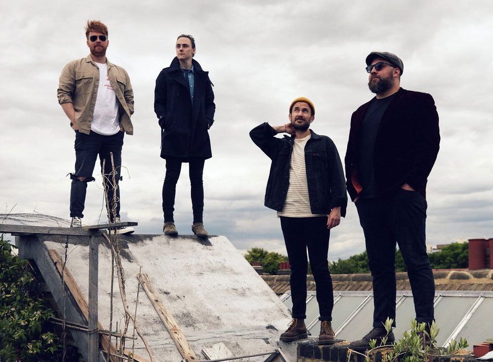 A group of men are standing on top of a roof.