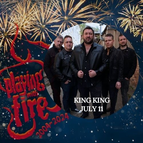 A group of men standing next to each other with fireworks in the background