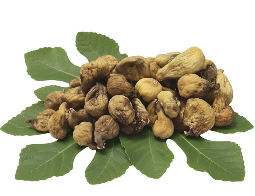 Pile of dried nuts or seeds on green leaves, isolated on a white background