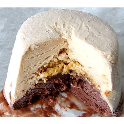 Cross-section of a layered dessert with white cream, caramel, and chocolate filling