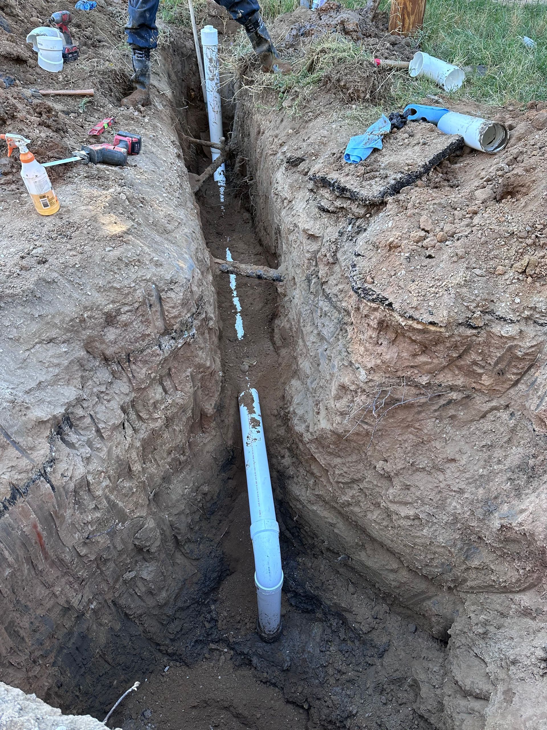A pipe is being installed in a hole in the ground.