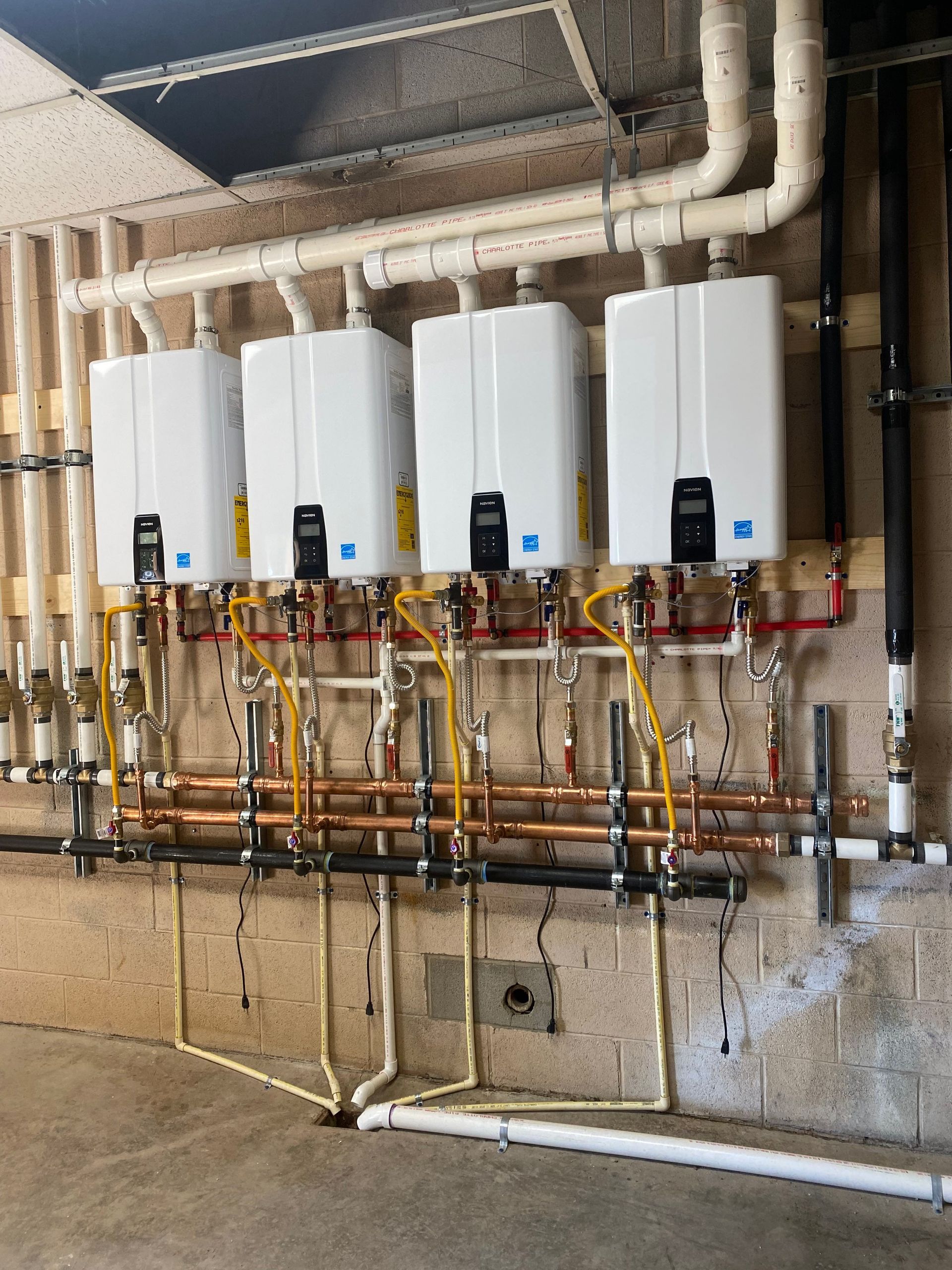 A row of water heaters are lined up on a wall